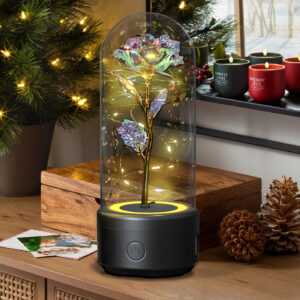 Rose flower LED night light in a glass dome on a wooden shelf beside pine cones