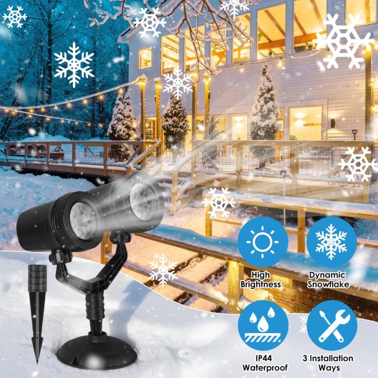 Dual-head snowflake projector on a ground stake, throwing rotating snow patterns across the wall of a house