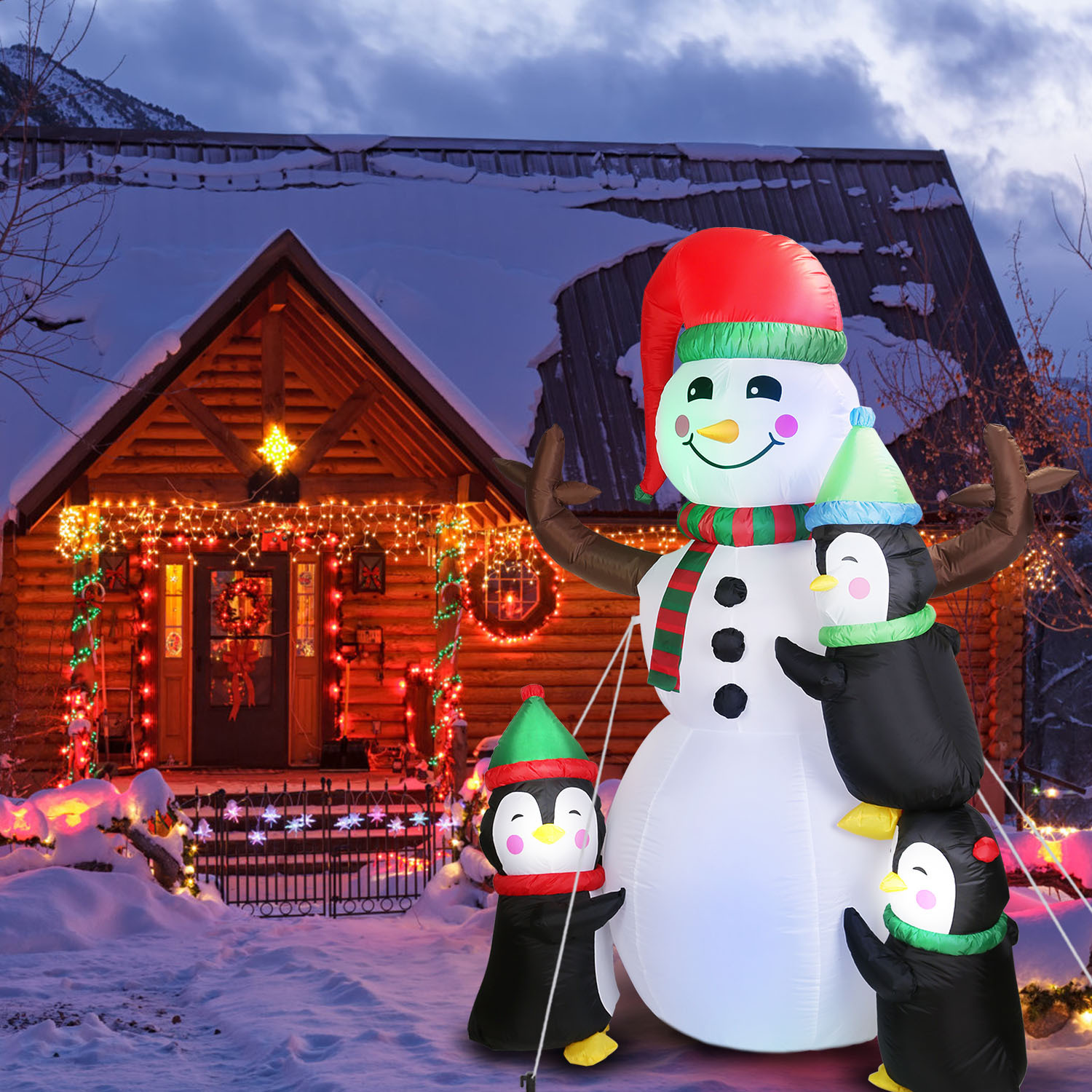 Inflatable snowman flanked by penguins, lit for the yard, view 3