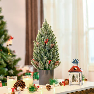 Flocked tabletop Christmas tree trimmed with pine cones and berries