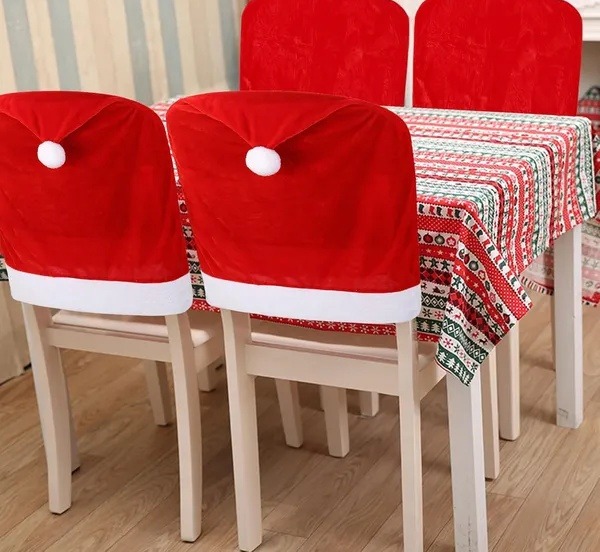 Santa hat chair back covers fitted to dining chairs at a set table