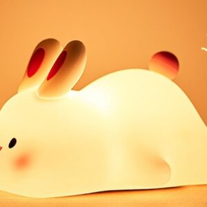 Silicone bunny night light glowing warm white on a wooden table