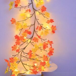 Lit autumn maple vine garland trailing down a plain wall