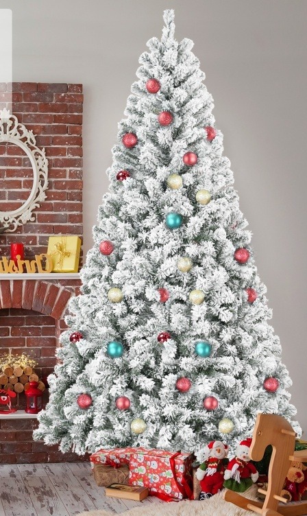 Snow flocked artificial Christmas tree decorated in a living room